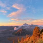 Beautiful sunset view over Mount Bromo in East Java, Indonesia with vibrant sky and volcanic landscape.