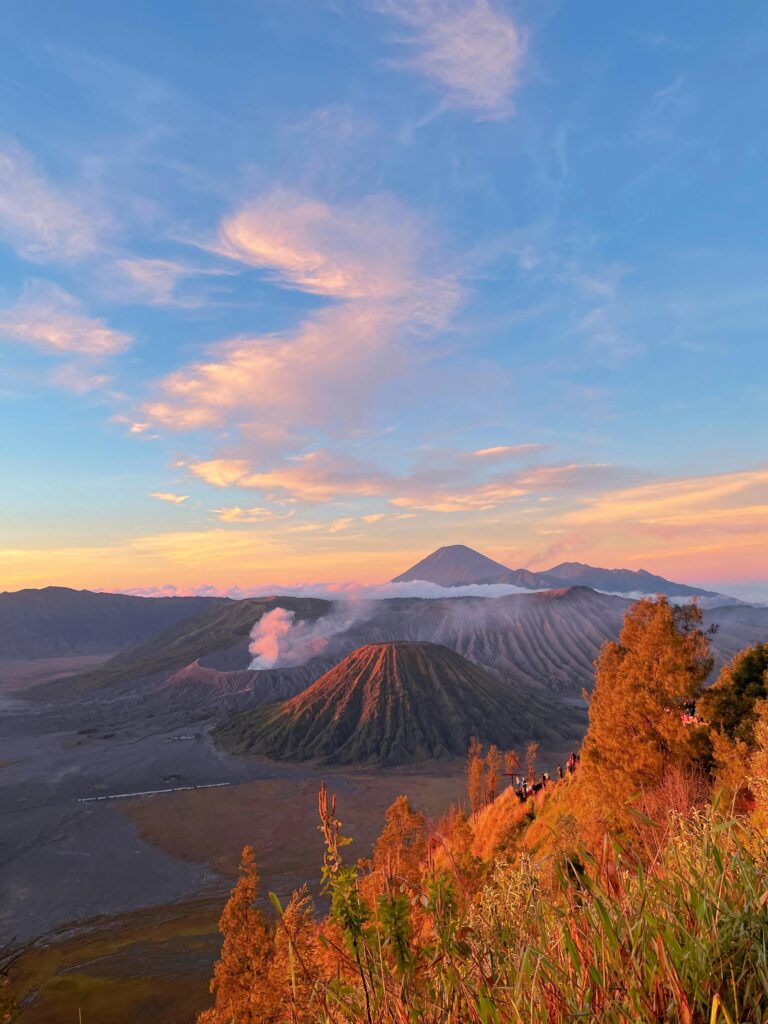 Beautiful sunset view over Mount Bromo in East Java, Indonesia with vibrant sky and volcanic landscape.